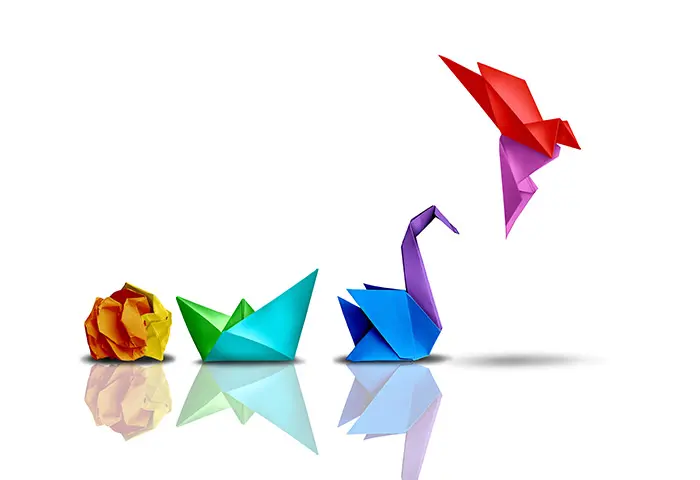 Illustration symbolique d’une transformation progressive et réussie, montrant des origamis évoluant d’une boule de papier froissée vers un oiseau qui prend son envol, illustrant la formation, l’amélioration, la transformation et la gestion RH grâce à Dynamiz